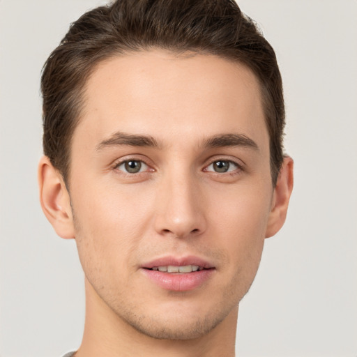 Joyful white young-adult male with short  brown hair and grey eyes