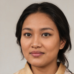 Joyful latino young-adult female with medium  brown hair and brown eyes