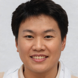 Joyful asian young-adult male with short  brown hair and brown eyes