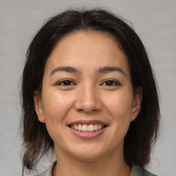 Joyful asian young-adult female with medium  brown hair and brown eyes