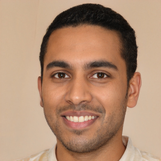 Joyful latino young-adult male with short  black hair and brown eyes