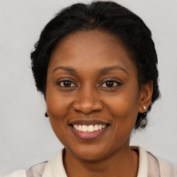 Joyful black adult female with medium  brown hair and brown eyes