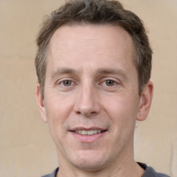 Joyful white adult male with short  brown hair and grey eyes