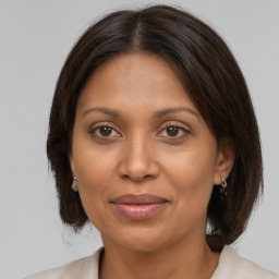 Joyful black adult female with medium  brown hair and brown eyes