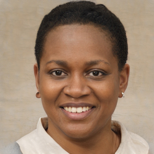 Joyful black young-adult female with short  black hair and brown eyes