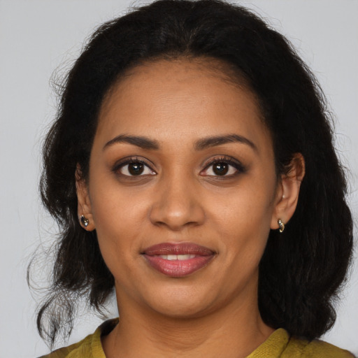 Joyful black young-adult female with medium  brown hair and brown eyes
