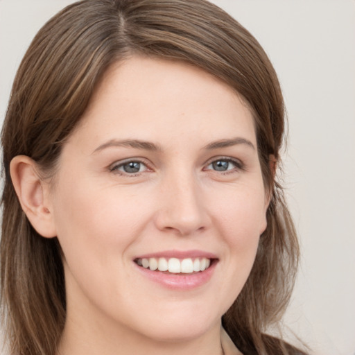 Joyful white young-adult female with long  brown hair and grey eyes