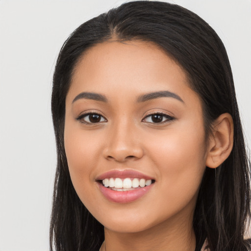 Joyful latino young-adult female with long  black hair and brown eyes