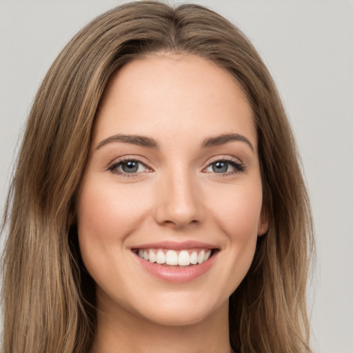 Joyful white young-adult female with long  brown hair and green eyes