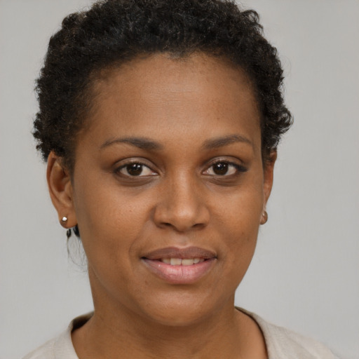 Joyful black young-adult female with short  brown hair and brown eyes