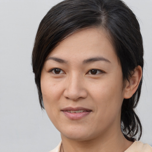 Joyful asian young-adult female with medium  brown hair and brown eyes