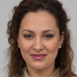 Joyful white adult female with long  brown hair and brown eyes