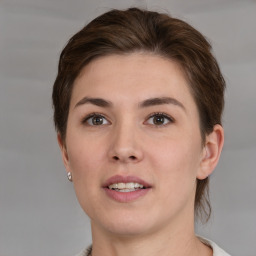 Joyful white young-adult female with medium  brown hair and grey eyes