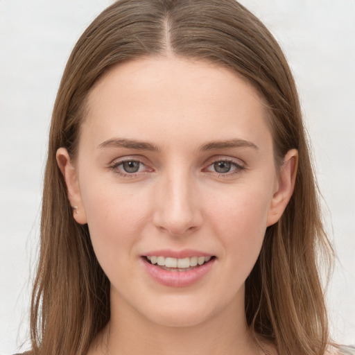 Joyful white young-adult female with long  brown hair and grey eyes