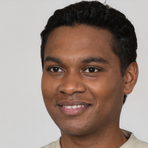 Joyful black young-adult male with short  black hair and brown eyes