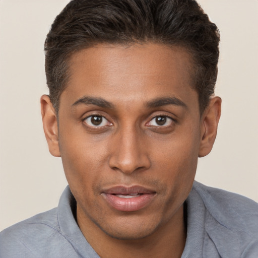 Joyful black young-adult male with short  brown hair and brown eyes