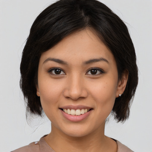 Joyful asian young-adult female with medium  brown hair and brown eyes