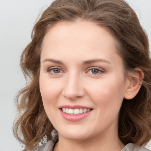 Joyful white young-adult female with long  brown hair and grey eyes