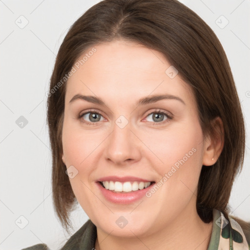 Joyful white young-adult female with medium  brown hair and grey eyes