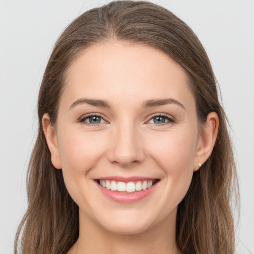 Joyful white young-adult female with long  brown hair and grey eyes