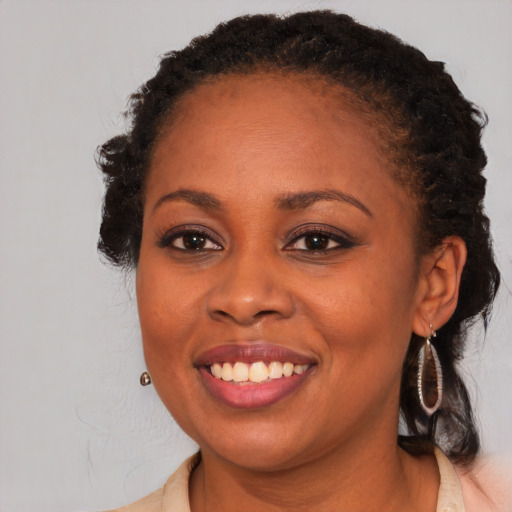 Joyful black young-adult female with long  brown hair and brown eyes