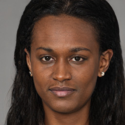 Joyful black young-adult female with long  brown hair and brown eyes