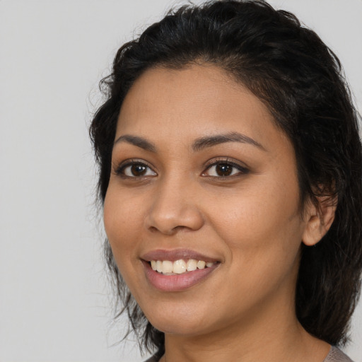 Joyful latino young-adult female with medium  brown hair and brown eyes