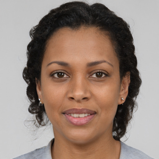 Joyful black young-adult female with medium  brown hair and brown eyes