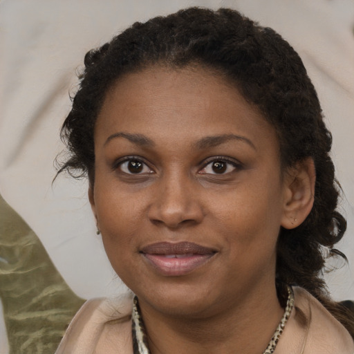 Joyful black young-adult female with long  brown hair and brown eyes
