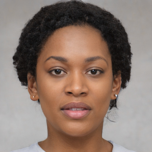 Joyful black young-adult female with short  black hair and brown eyes