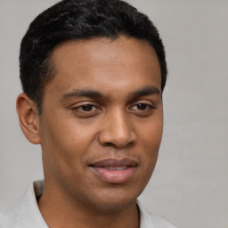 Joyful latino young-adult male with short  brown hair and brown eyes