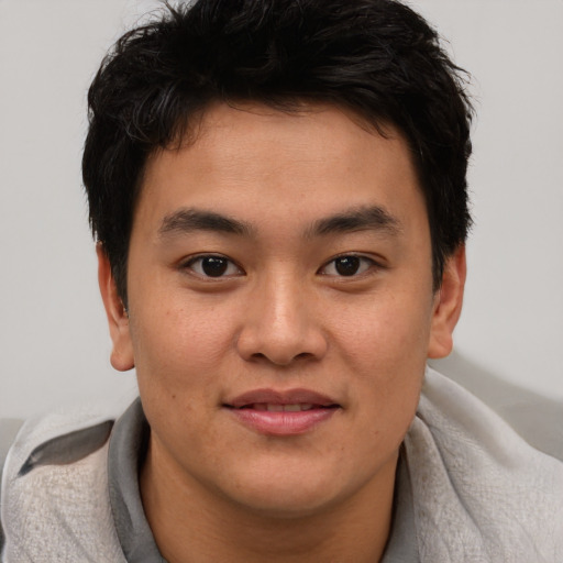 Joyful asian young-adult male with short  brown hair and brown eyes