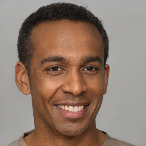 Joyful latino adult male with short  brown hair and brown eyes