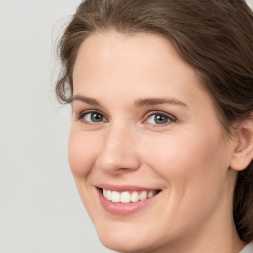 Joyful white young-adult female with medium  brown hair and green eyes