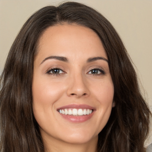 Joyful white young-adult female with long  brown hair and brown eyes