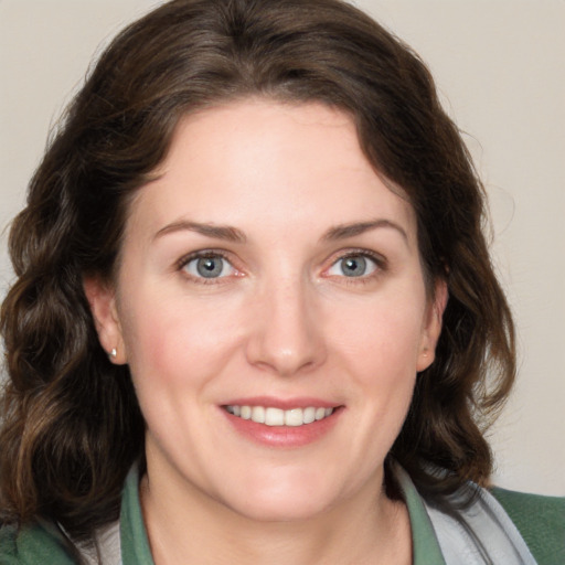 Joyful white young-adult female with medium  brown hair and green eyes