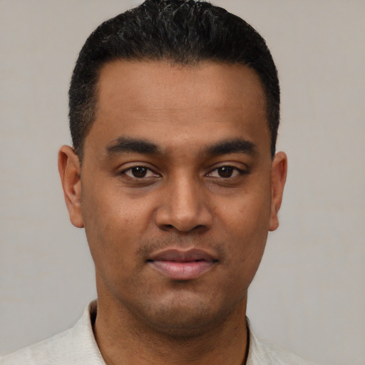 Joyful latino young-adult male with short  black hair and brown eyes