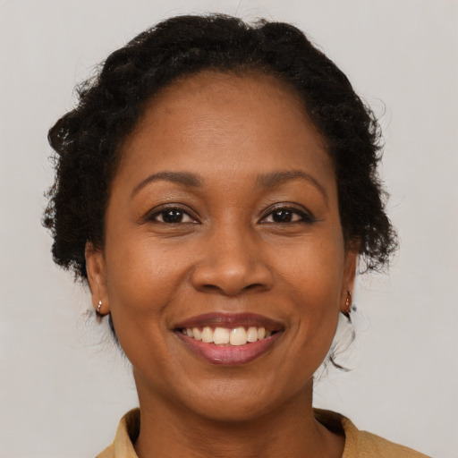 Joyful black adult female with medium  brown hair and brown eyes
