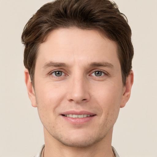 Joyful white young-adult male with short  brown hair and grey eyes