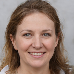 Joyful white adult female with medium  brown hair and grey eyes