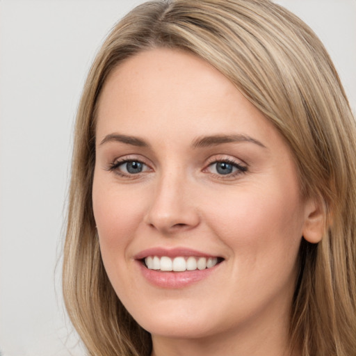 Joyful white young-adult female with long  brown hair and grey eyes