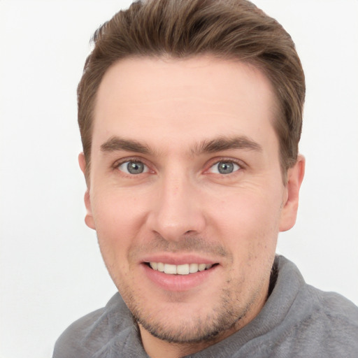 Joyful white young-adult male with short  brown hair and grey eyes