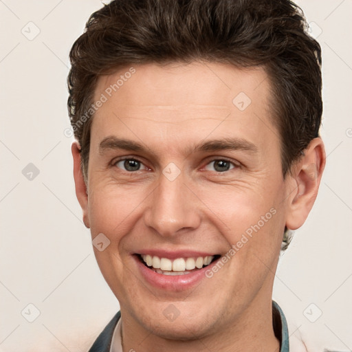 Joyful white young-adult male with short  brown hair and grey eyes