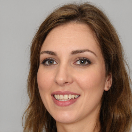 Joyful white young-adult female with long  brown hair and green eyes