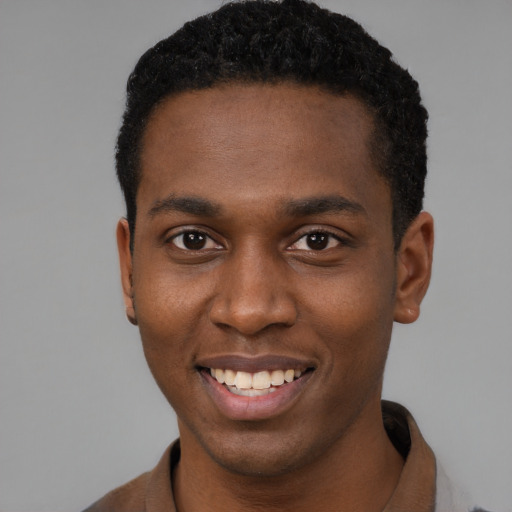 Joyful black young-adult male with short  brown hair and brown eyes