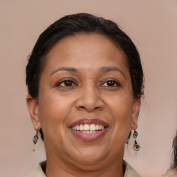 Joyful latino adult female with medium  brown hair and brown eyes