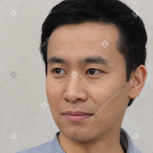 Joyful asian young-adult male with short  black hair and brown eyes