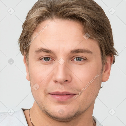 Joyful white young-adult male with short  brown hair and grey eyes