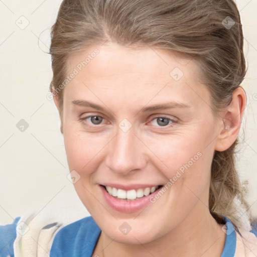 Joyful white young-adult female with medium  brown hair and blue eyes