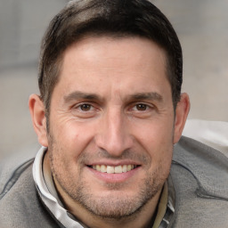 Joyful white adult male with short  brown hair and brown eyes